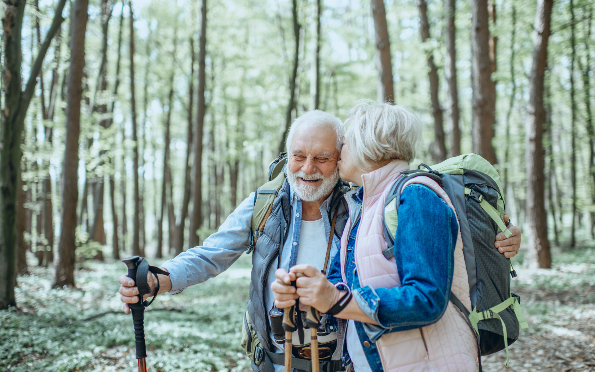 couple-hiking-in-woods-together-with-a-kiss
